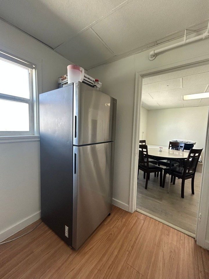 Kitchen with stainless refrigerator at The Nest